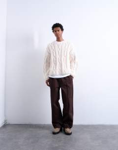 Model wearing Hand knit cable jumper in ecru