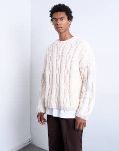 Model wearing Hand knit cable jumper in ecru