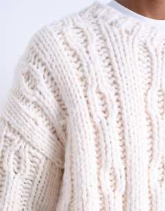 Model wearing Hand knit cable jumper in ecru