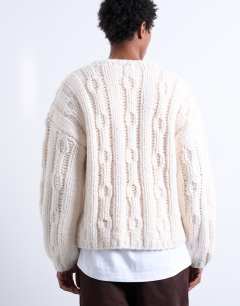 Model wearing Hand knit cable jumper in ecru