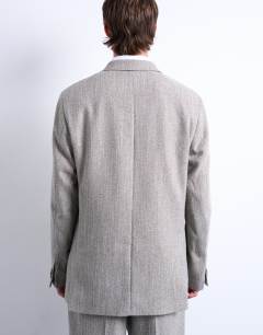 Model wearing Herringbone double breasted blazer in stone