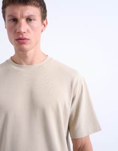 Model wearing Interlock relaxed fit t-shirt in stone