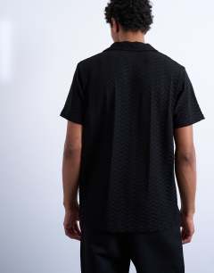 Model wearing Jersey zig zag polo top in black