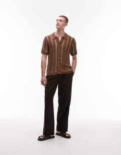 Model wearing Knitted viscose button through polo with metallic stripe in brown