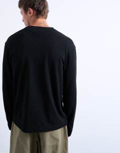 Model wearing Long sleeve relaxed fit waffle t-shirt with henley in black