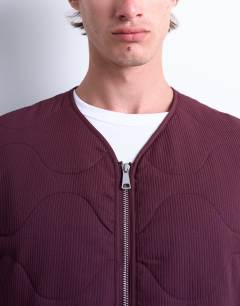 Model wearing Onion quilted gilet in burgundy
