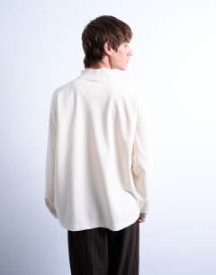 Model wearing Oversized fit high neck long sleeve t-shirt in ecru