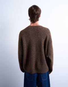 Model wearing Oversized fit knitted v-neck jumper in brown