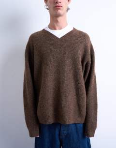 Model wearing Oversized fit knitted v-neck jumper in brown