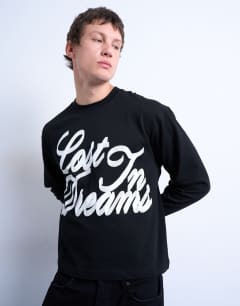 Model wearing Oversized fit long sleeve t-shirt with lost in dreams print in black