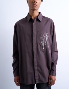 Model wearing Oversized fit poplin shirt with floral embroidery in brown