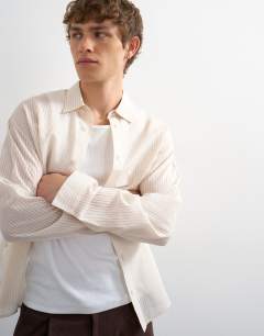 Model wearing Oversized fit sheer stripe shirt in ecru