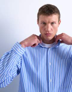 Model wearing Oversized fit stripe shirt in blue