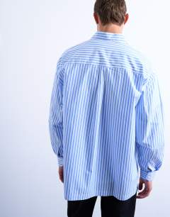 Model wearing Oversized fit stripe shirt in blue