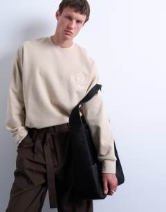 Model wearing Oversized fit sweatshirt with raised floral print in stone
