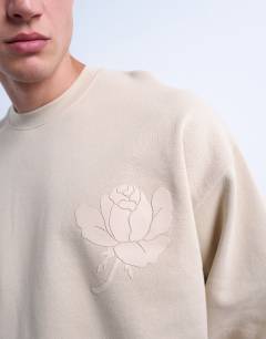 Model wearing Oversized fit sweatshirt with raised floral print in stone