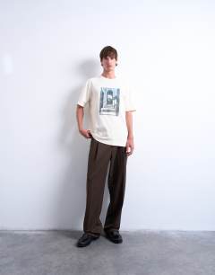 Model wearing Oversized fit t-shirt with doorway image print and embroidery in ecru