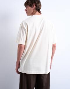 Model wearing Oversized fit t-shirt with doorway image print and embroidery in ecru