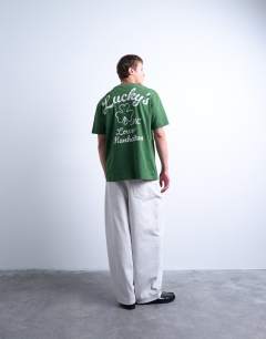 Model wearing Oversized fit t-shirt with front and back lucky print in washed green