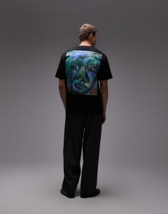 Model wearing Oversized fit t-shirt with front and back painted face graphic in black