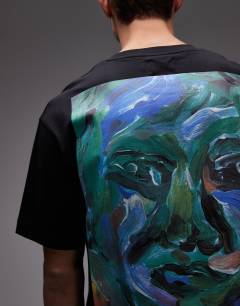 Model wearing Oversized fit t-shirt with front and back painted face graphic in black