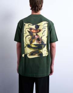 Model wearing Oversized fit t-shirt with front and back watercolour shapes print in dark green
