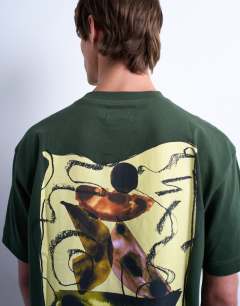 Model wearing Oversized fit t-shirt with front and back watercolour shapes print in dark green