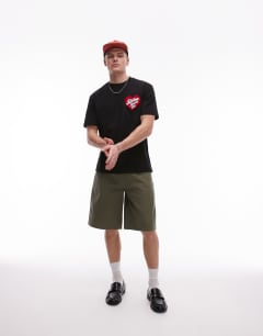 Model wearing Oversized fit t-shirt with stolen hearts club patch embroidery in black