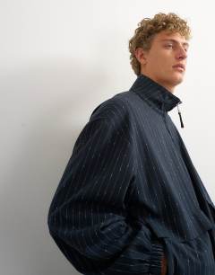 Model wearing Oversized fit tailored funnel neck bomber with boucle pinstripe in navy