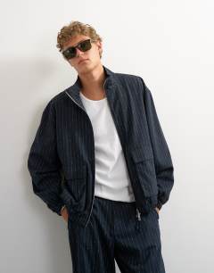 Model wearing Oversized fit tailored funnel neck bomber with boucle pinstripe in navy