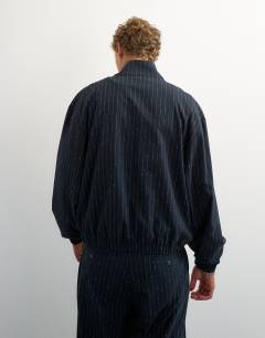 Model wearing Oversized fit tailored funnel neck bomber with boucle pinstripe in navy