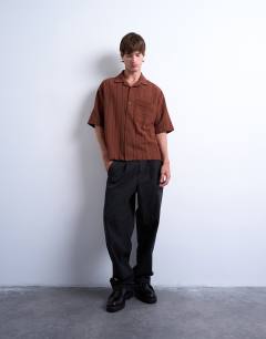 Model wearing Oversized fit textured stripe button through polo in brown