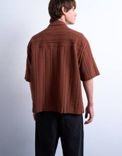 Model wearing Oversized fit textured stripe button through polo in brown