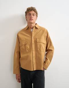 Model wearing Oversized fit utility shirt in tan