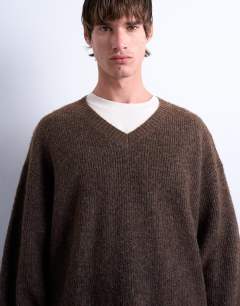 Model wearing Oversized fit v neck jumper in brown