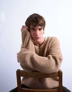 Model wearing Oversized fit v neck jumper in stone