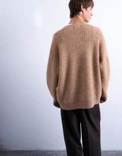 Model wearing Oversized fit v neck jumper in stone