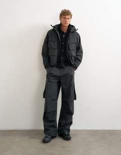 Model wearing Oversized fit waterproof nylon utility jacket in black