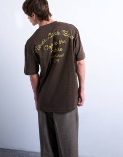 Model wearing Oversized Pegasus embroidered t-shirt with back text in brown