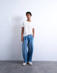 Model wearing Pleated barrel jean in mid wash blue