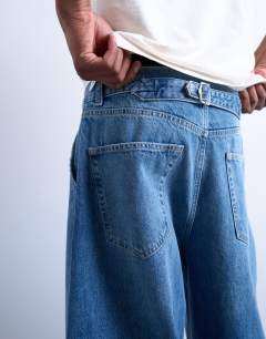 Model wearing Pleated barrel jean in mid wash blue