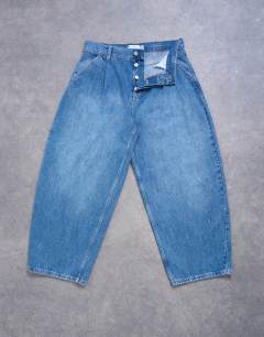 Model wearing Pleated barrel jean in mid wash blue