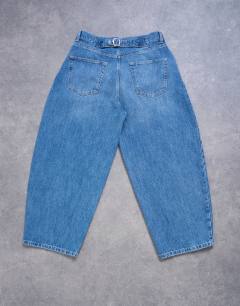 Model wearing Pleated barrel jean in mid wash blue