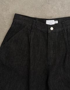 Model wearing Pleated barrel jean in mid wash blue