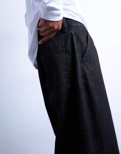 Model wearing Pleated barrel jean in raw black