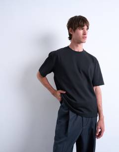 Model wearing Premium heavyweight crop t-shirt in black