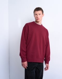 Model wearing Premium lightweight oversized fit sweatshirt in burgundy
