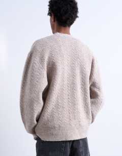 Model wearing Relaxed fit cable knitted cardigan in stone