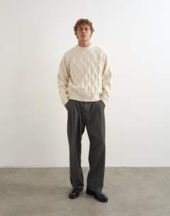 Model wearing Relaxed fit cable knitted jumper in ecru