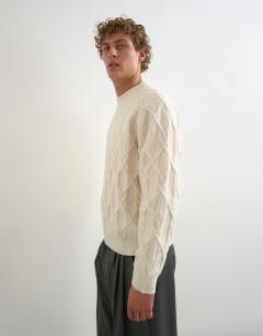 Model wearing Relaxed fit cable knitted jumper in ecru